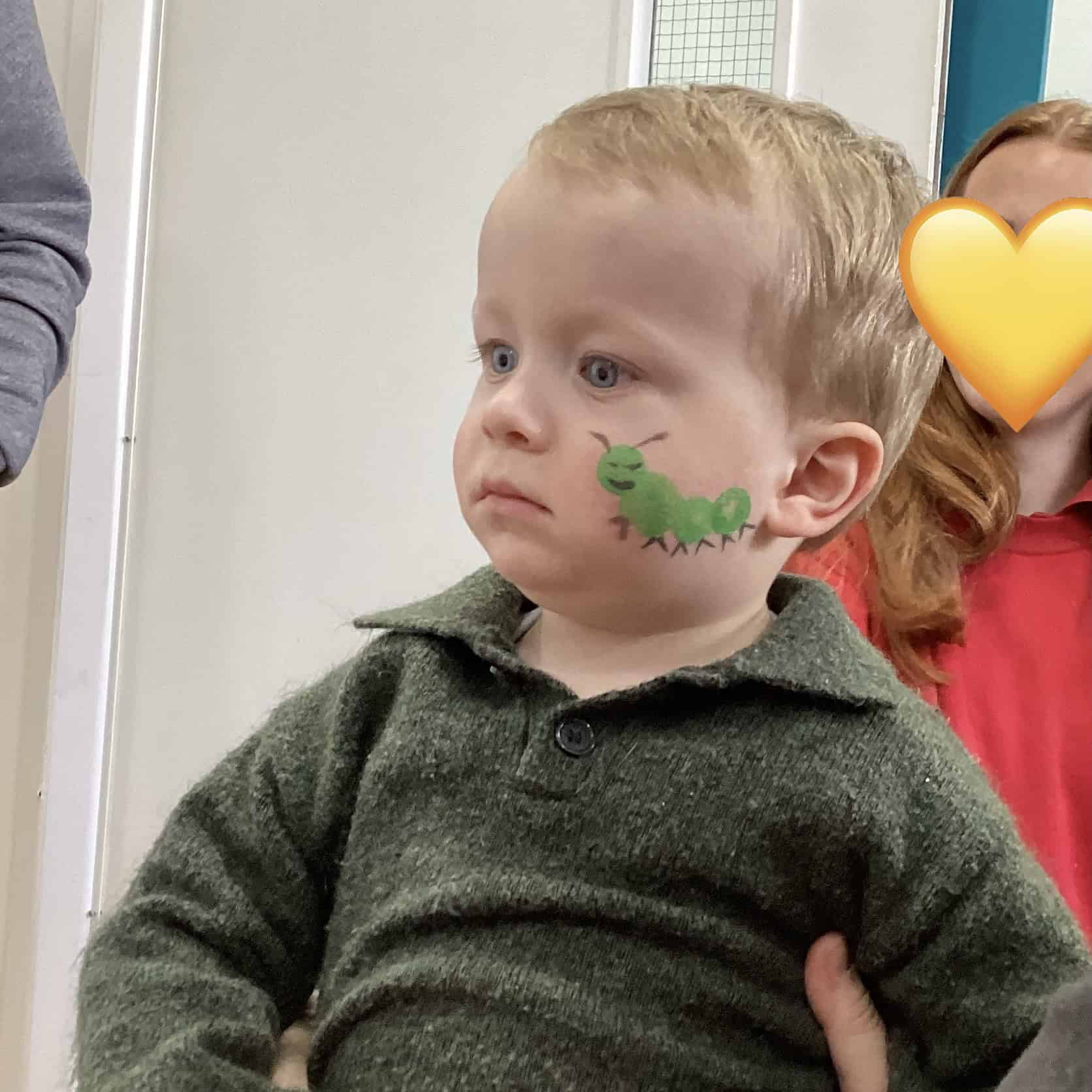 Young boy with caterpillar face paint
